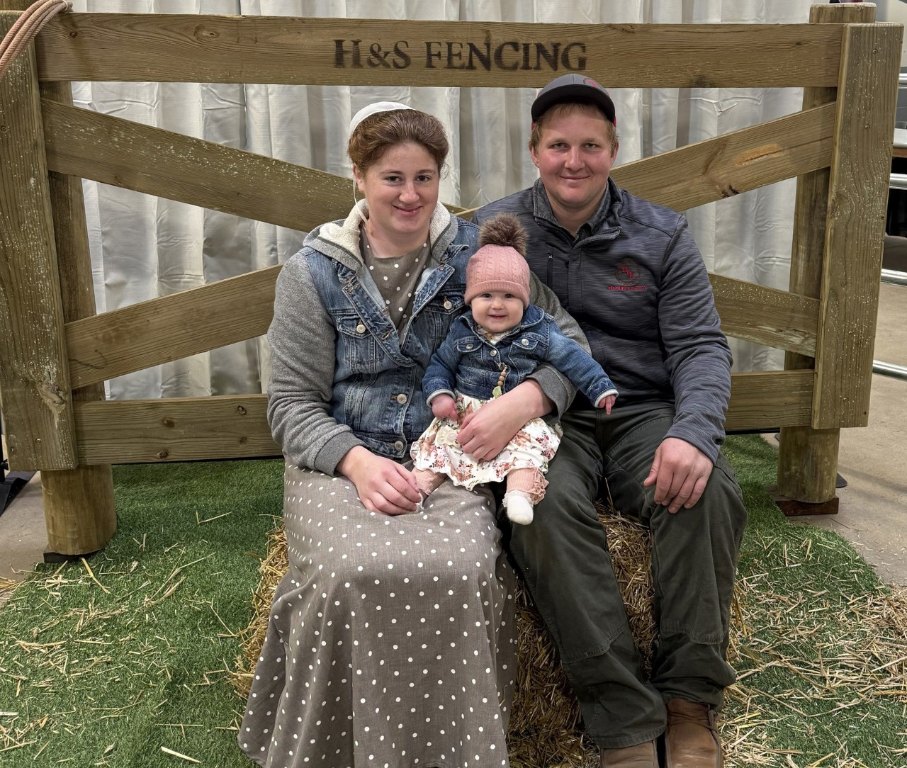H&S Fencing & Supply family seated in front of a wooden fence panel branded H&S Fencing
